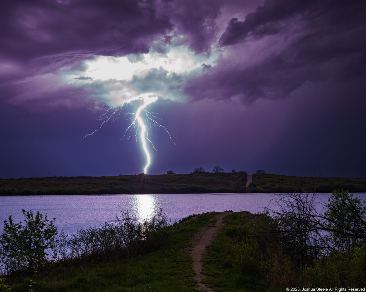 Image of a lightning bolt strike over a lake at night