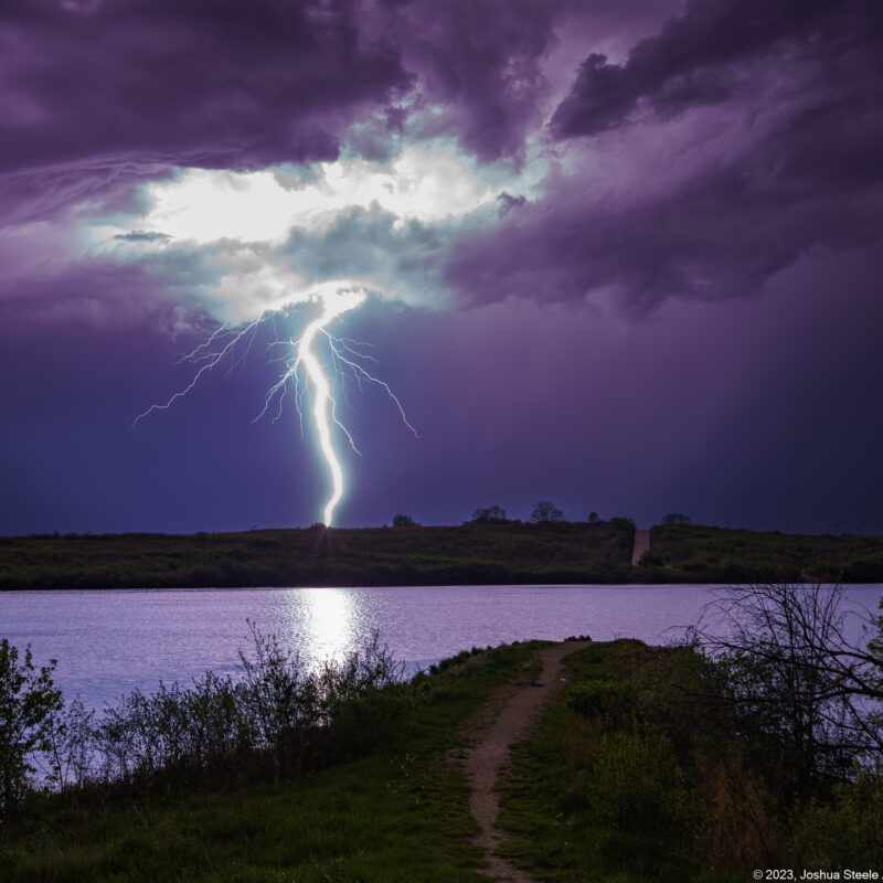 Image of a lightning bolt strike over a lake at night