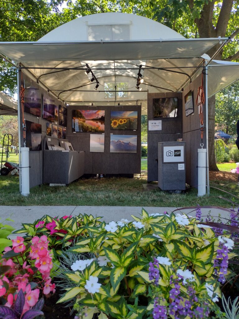 Image of an art booth with flowers in front of it